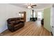 Bright living area featuring leather furniture and fireplace, complemented by light-filled windows and hardwood floors at 150 Big Horn Cv, Louisburg, NC 27549