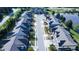 An aerial view features a well-maintained community with neatly arranged townhomes, street trees, and a calm lake in the background at 150 Red Admiral Ct, Hillsborough, NC 27278
