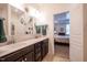 Bathroom featuring double sinks with dark wood cabinets and a view into the bedroom at 150 Red Admiral Ct, Hillsborough, NC 27278