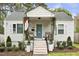 Welcoming front of a home with a porch featuring seating, flower pots, and a blue-painted front door at 2008 Reaves Dr, Raleigh, NC 27608