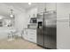 Bright kitchen with stainless steel refrigerator and microwave, white cabinets, and a cozy breakfast nook at 2008 Reaves Dr, Raleigh, NC 27608