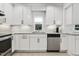 Modern kitchen with white cabinetry, stainless steel dishwasher, granite counters and sleek hardware at 2008 Reaves Dr, Raleigh, NC 27608