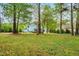 Green backyard with mature trees offering shade and privacy at 201 Blue Heron Dr, Youngsville, NC 27596