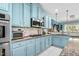 Quaint kitchen featuring granite countertops, stainless appliances, and blue cabinetry at 201 Blue Heron Dr, Youngsville, NC 27596