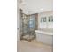 Bright bathroom featuring a walk-in shower and a modern soaking tub by a large window at 206 Zapata Ln, Chapel Hill, NC 27517