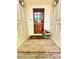 Charming front door entrance with brick steps and a basket of firewood, flanked by sconces at 206 Zapata Ln, Chapel Hill, NC 27517