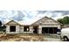 New construction of a single-story home, featuring a covered structure and visible framing under cloudy skies at 21 Shoreline Dr, Lillington, NC 27546