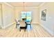 Elegant dining room with a round table, four chairs, and a modern chandelier over light wood floors at 21 Shoreline Dr, Lillington, NC 27546