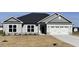 Charming single-story home featuring gray siding, stone accents, and a two-car garage at 21 Shoreline Dr, Lillington, NC 27546