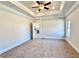 Spacious main bedroom with tray ceilings, ceiling fan and neutral carpeting at 21 Shoreline Dr, Lillington, NC 27546