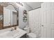 Compact bathroom with decorative mirror, vanity, toilet, and a shower with a white curtain at 2102 Trailridge Ct, Raleigh, NC 27603