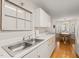 Bright kitchen with white cabinets, stainless steel sink, and hardwood floors at 2102 Trailridge Ct, Raleigh, NC 27603