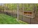 Fenced backyard featuring lush lawn, treed perimeter, and a wood shed at 2204 Secluded Oaks Ct, Wake Forest, NC 27587