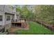 Fenced backyard features lush lawn, treed perimeter, and a spacious deck with black railings at 2204 Secluded Oaks Ct, Wake Forest, NC 27587