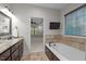 Bright bathroom featuring double vanity, soaking tub, and tile accents at 2204 Secluded Oaks Ct, Wake Forest, NC 27587