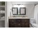 Elegant bathroom featuring a double vanity with granite countertop, framed mirrors, and a convenient linen closet at 2204 Secluded Oaks Ct, Wake Forest, NC 27587
