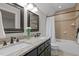 Bathroom showcases granite countertop, double sinks, stylish mirrors, tub/shower with tiled surround and glass door at 2204 Secluded Oaks Ct, Wake Forest, NC 27587