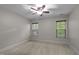Bright bedroom with two windows, neutral walls, carpet, trim, and a ceiling fan at 2204 Secluded Oaks Ct, Wake Forest, NC 27587