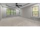 Spacious bedroom with tray ceilings, plush carpet, and ample natural light from multiple windows at 2204 Secluded Oaks Ct, Wake Forest, NC 27587
