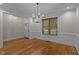 Bright dining room featuring hardwood floors, modern lighting, and wainscoting details at 2204 Secluded Oaks Ct, Wake Forest, NC 27587
