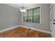 Bright dining area featuring hardwood floors, gray walls, trim detail, and modern light fixture at 2204 Secluded Oaks Ct, Wake Forest, NC 27587