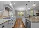Open kitchen with granite countertops, stainless steel appliances, and hardwood floors at 2204 Secluded Oaks Ct, Wake Forest, NC 27587