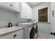 Well-equipped laundry room with sink, cabinets, washer, and dryer at 2204 Secluded Oaks Ct, Wake Forest, NC 27587