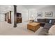 Finished basement area with a large sectional sofa and support columns at 2416 W Club Blvd, Durham, NC 27705