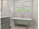 Clawfoot bathtub in a bathroom with hexagon tile flooring, and a double window at 2416 W Club Blvd, Durham, NC 27705