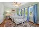 Bright bedroom with hardwood floors, large windows, and blue curtains at 2416 W Club Blvd, Durham, NC 27705