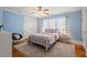 Blue bedroom with hardwood floors, neutral carpet and trim, ceiling fan, and windows at 2416 W Club Blvd, Durham, NC 27705