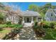 Charming home with a stone pathway, a welcoming front porch, and mature landscaping with flowering plants at 2416 W Club Blvd, Durham, NC 27705