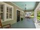 Charming front porch with blue ceiling, rocking chair, pendant light, and black screen door with wreath at 2416 W Club Blvd, Durham, NC 27705