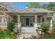 Close up of charming porch with white columns and rails and a stone pathway and landscaped beds leading to it at 2416 W Club Blvd, Durham, NC 27705
