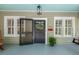 Charming front porch with blue ceiling, rocking chair, pendant light, and black screen door with wreath at 2416 W Club Blvd, Durham, NC 27705