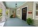 Charming front porch with blue ceiling, rocking chair, pendant light, and black screen door with wreath at 2416 W Club Blvd, Durham, NC 27705