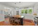 Open kitchen showcasing a large center island with seating, white cabinetry, and stainless steel appliances at 2416 W Club Blvd, Durham, NC 27705