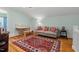 Upstairs living area with a comfortable sofa, work desk, hardwood floors, and a bright rug at 2416 W Club Blvd, Durham, NC 27705