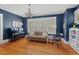 Elegant living room featuring hardwood floors, a piano, and built-in bookshelves with detailed trim work at 2416 W Club Blvd, Durham, NC 27705
