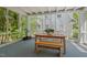 Charming screened porch with a wooden table, bench, and view of the surrounding greenery at 2416 W Club Blvd, Durham, NC 27705
