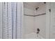 Tiled shower with a bathtub and classic blue patterned curtain at 2416 W Club Blvd, Durham, NC 27705
