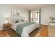 Well-lit primary bedroom with a plush bed, stylish lamps, and access to a private balcony at 2916 Rue Sans Famille, Raleigh, NC 27607