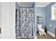 Cozy bathroom with a floral shower curtain and a decorative basket shelf at 303 E J St, Erwin, NC 28339