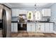 Bright kitchen with stainless steel appliances, white cabinets, and a charming lemon-themed rug at 303 E J St, Erwin, NC 28339