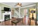 Open-concept living room with hardwood floors, a decorative fireplace, and stairs leading to the upper level at 303 E J St, Erwin, NC 28339