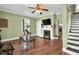 Cozy living room features classic hardwood floors, a decorative fireplace, and stairs leading to the upper level at 303 E J St, Erwin, NC 28339
