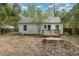 Backyard view with white siding home, wood deck, trees, and a tree stump at 312 Greenwood Dr, Durham, NC 27704