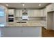 Elegant kitchen featuring a large island, stainless steel appliances, and sleek white cabinetry at 316 Catheys Creek Cir, Wendell, NC 27591