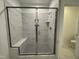 Modern bathroom shower with marble tile, glass door, and built-in bench seating at 316 Catheys Creek Cir, Wendell, NC 27591