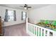 Bright bedroom features a ceiling fan, carpeted floor, and a window with charming patterned curtains at 317 City Center Ln, Wendell, NC 27591